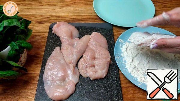 I dry the chicken fillet and cut it into 2 parts. Add salt and pepper to the flour and roll the fillets in it.