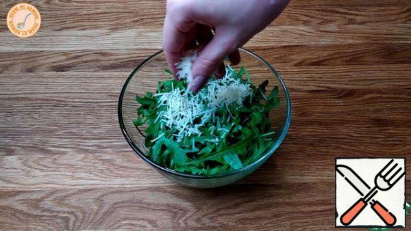 Prepare a salad of arugula and Parmesan.