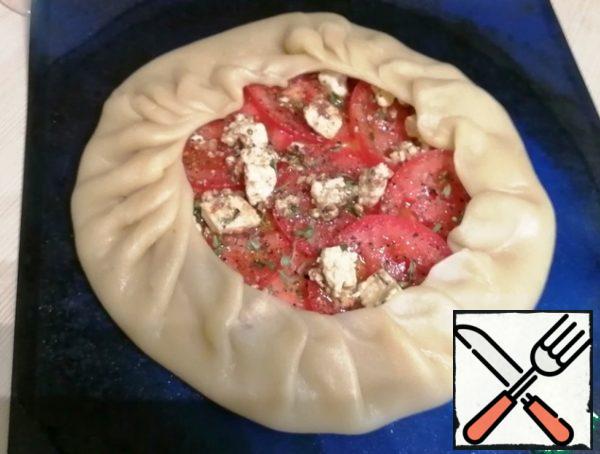 Cut the tomato into circles. You can take 2 tomatoes, and if small, then more. Spread over the cheese.
Add salt and pepper, add thyme leaves (I had dried thyme this time, but with fresh it turns out much more piquant and fragrant).
Crumble the feta on top. I had feta in butter with sun-dried tomatoes. You can, by the way, add dried tomatoes to your taste.
Pour a little olive oil over everything