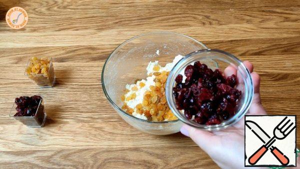 Add raisins and dried cranberries to the curd mass, mix, let stand for 1 hour.