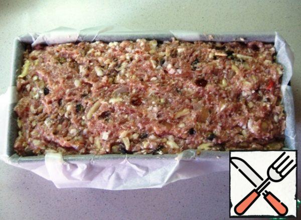 Put the minced meat in a rectangular shape (the size of the form is 11 cm wide, 7 cm high, 25 cm long; covered with parchment and greased the sides with vegetable oil).
