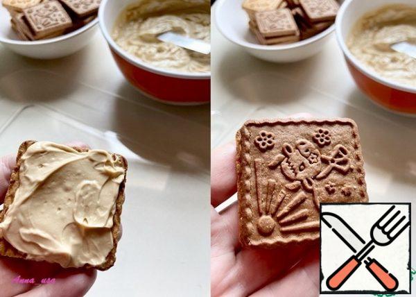 We take two cookies (white and chocolate) and fasten them with cream. Cookies are greased liberally.