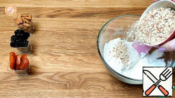 Chop the almonds. Combine flour, starch and baking powder. Add the nuts to the flour