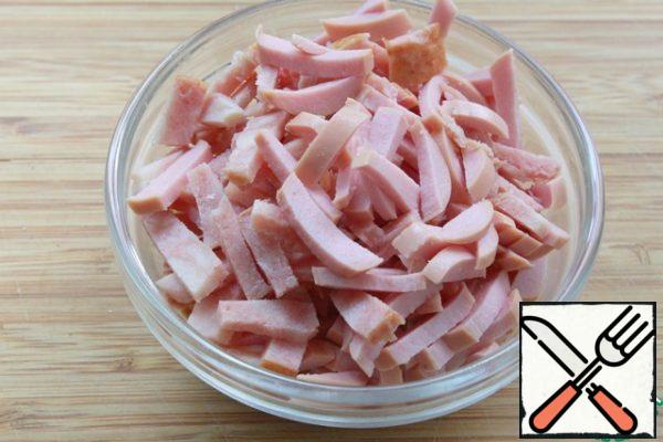 Cut the sausage and sausage into short strips.