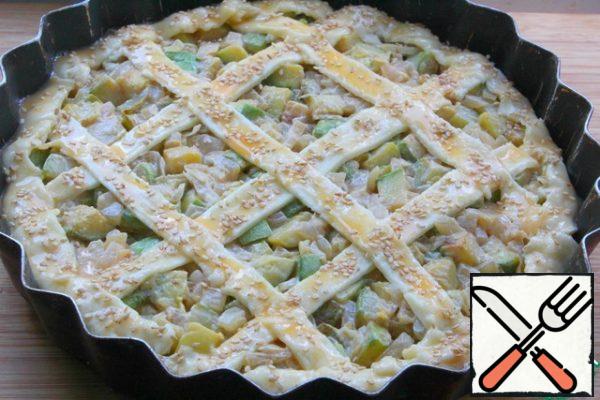 Spread the zucchini layer on top.
Make strips from the remaining dough.
Make a pie.
Brush with egg yolk and sprinkle with sesame seeds if desired.