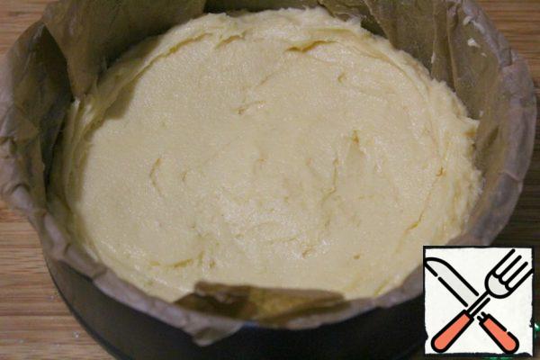 Cover the 20 cm form with parchment.
Put the dough into a mold, smooth it out, making the edges higher, and in the middle of the recess.