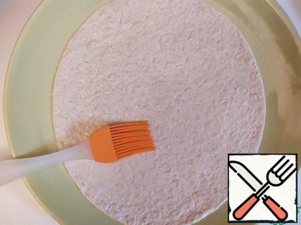 Brush the tortilla with olive oil.