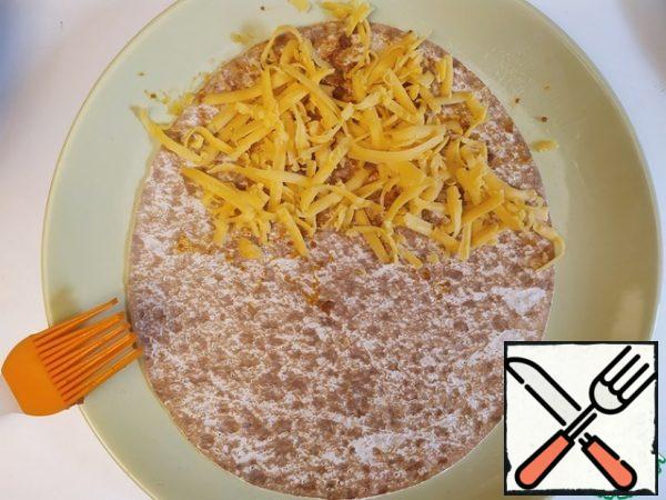 Flip over. Half spread the grated cheese.
