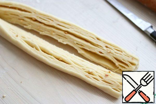 Next, cut the roll lengthwise into two parts, not reaching the edge of about 2-3 cm.