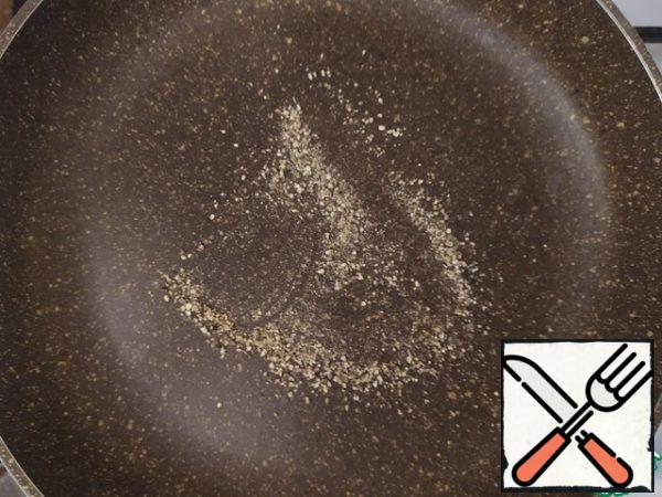 We take black pepper either in peas and roughly break it in a mortar, or use a mill with the possibility of coarse grinding.

Fry it in a dry pan for 1-2 minutes.
