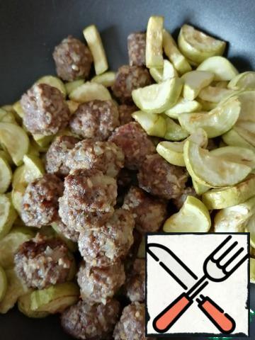 Put the zucchini and meatballs in a deep pan.
Cut potatoes into quarters, mix with oil and spices to taste and bake.