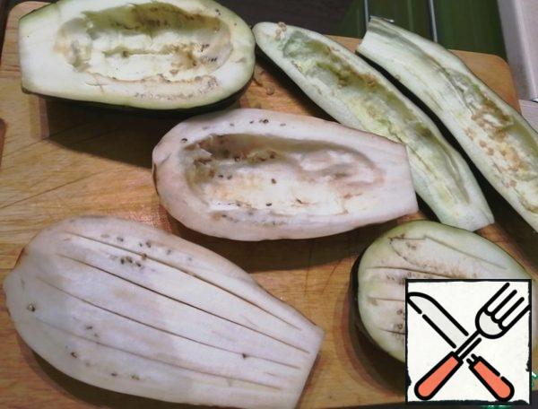 Cut the eggplant lengthwise. Next, there are two options: make cuts in the middle, but not to the end, or remove part of the pulp. I always do the second option, because this way more filling fits. This time I made half a boat, half incisions.
Add salt and place in a bowl. Leave for an hour (or less, I have about half an hour, have never been bitter)
