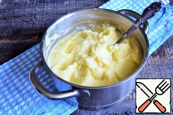 Pour the cream and yolk mass into the hot potatoes, then mash these.
Add milk if desired.