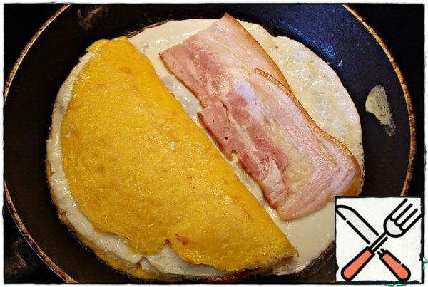 On the empty part of the pan, pour half of the remaining protein, after setting, spread the remaining part of the meat filling and cover with half of the filling.