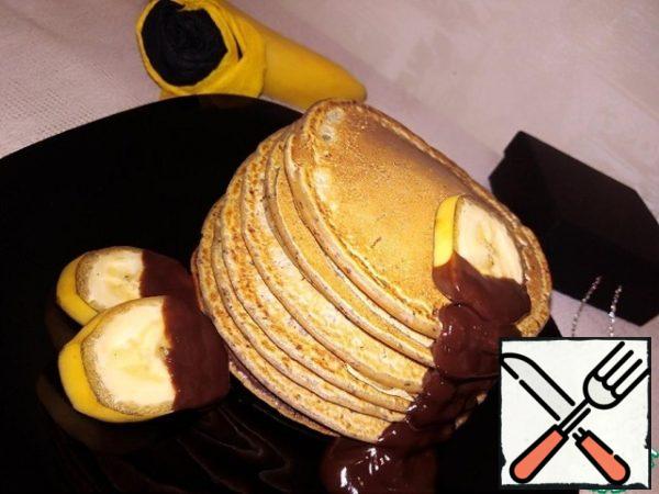 Serve the pancakes warm.
Put 8 pieces on top of each other or divide into 2 portions (4 pieces each).
Garnish with banana slices and hot chocolate icing.