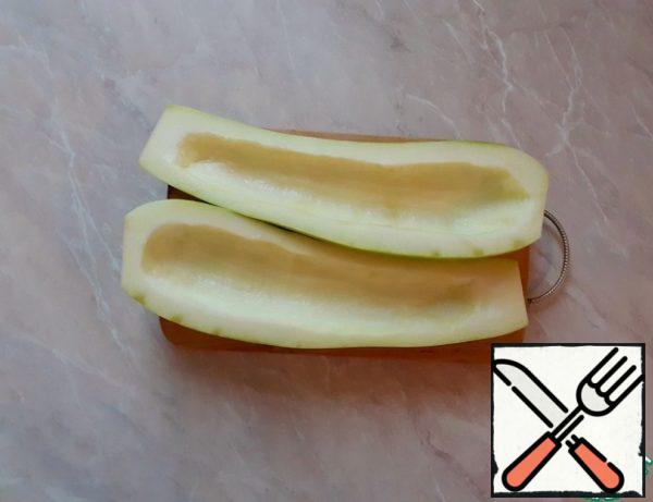 First, peel the zucchini if it's big, like mine.
If it is small, skip this step.
Cut the zucchini in half lengthwise and remove the core. We won't need it anymore.
If the zucchini is large, like mine, cook for 2 minutes (no more) in boiling salted water.
If they are small, skip this step.
Salt the zucchini on the cut side and set aside.