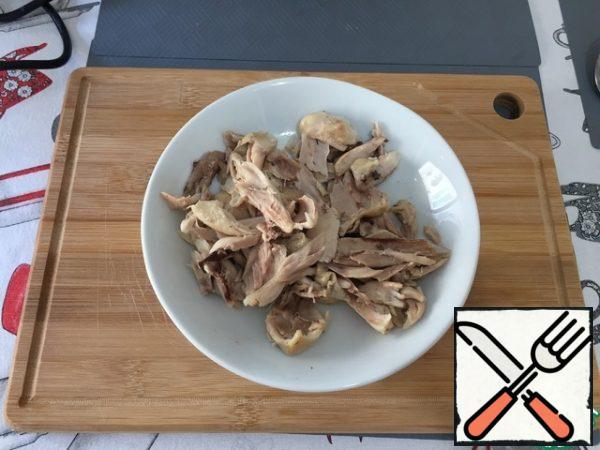 After cooking the chicken legs, let the meat cool and separate it from the bones.