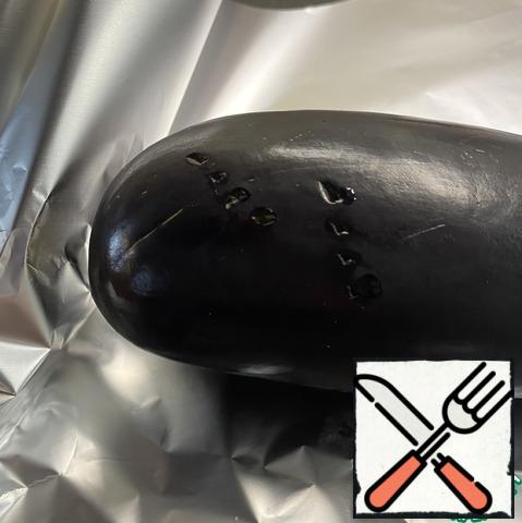 Wash the eggplant, wipe it dry, and pierce it in several places with a fork.Wrap the eggplant in foil, at least 4 layers. In the ends of the eggplant stick forks, they will serve as a spit.