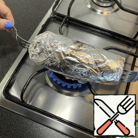 Turn on the largest gas burner on medium heat, place the eggplant on the grill above the burner, slowly rotate the eggplant along the axis.