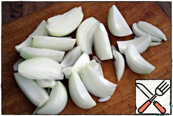 Cut the onion in half, then cut each half from the center of the flat side at an angle into three or four slices and throw it into the baking tray...