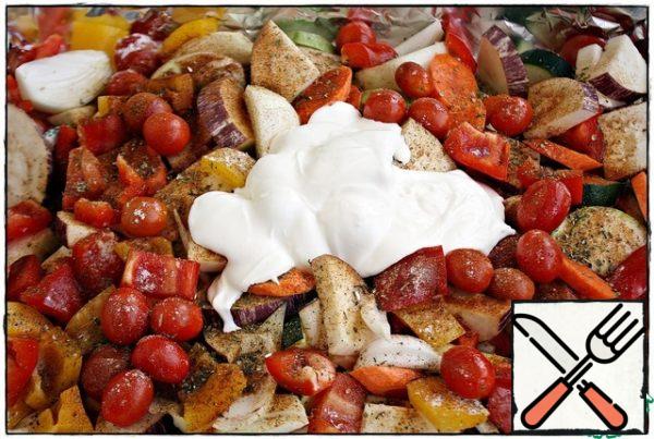 Now it's time for spices. Sprinkle the vegetables on top with salt and black pepper, paprika and hops-suneli, pour olive oil and add sour cream...