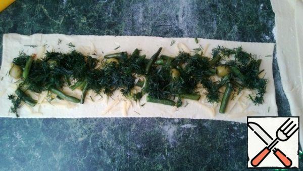 Put the cheese on each strip of dough, place the olives and string beans on top. You can sprinkle any fresh herbs.