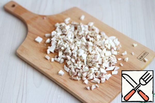 Chop the mushrooms (2 PCs.) into crumbs. Add 2 tablespoons of melted butter to the pan and fry the mushrooms in oil.