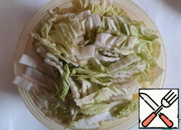 While the minced meat is being prepared, cut the cabbage into thin strips.