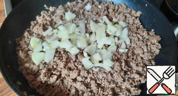 Add the onion to the minced meat, fry for a couple of minutes, do not forget to stir, salt, pepper (a little, take into account the salinity of the feta).
Transfer the minced meat from the pan.