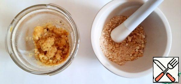 Melt two tablespoons of butter, mix with bread crumbs.
Nuts are crushed in a convenient way, mixed with bread and butter crumbs.
