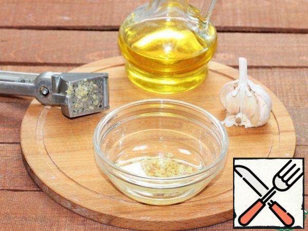 Peel the garlic and pass it through the presser. Fill the garlic with vegetable oil, mix and leave aside for half an hour.