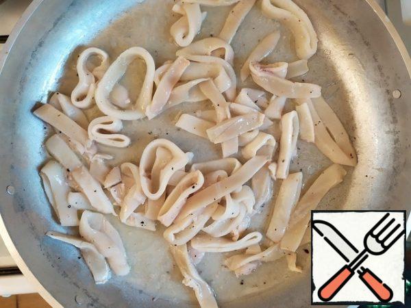 Heat the olive oil, add the squid rings and fry for a couple of minutes.