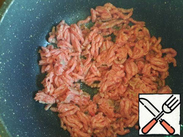 Preheat a deep frying pan or saucepan. Pour in 2 tablespoons of vegetable oil and fry the minced meat in it for 7-8 minutes.