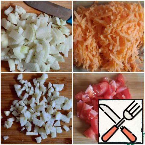 Cut the onion into small cubes, grate the carrot, cut the tomato into cubes, and chop the garlic.