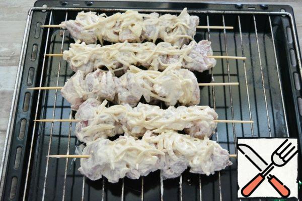 Soak the bamboo skewers in water for 10 minutes. Then string the pieces of shish kebab on them.

On a baking sheet, place the grill from the oven, put the skewers on it. Carefully put all the onion and mayonnaise on top.