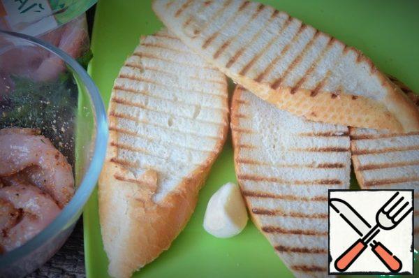 Cut the baguette into slices obliquely, dry it on the grill, and RUB it with garlic.
Cut the peeled tomato, mozzarella, garlic petal, herbs, add mustard, balsamic and mix.