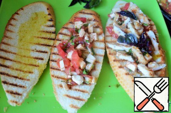 Sprinkle the baguette with olive oil, put the tomato and cheese mass on top of the sliced grilled Turkey, sprinkle with olive oil.