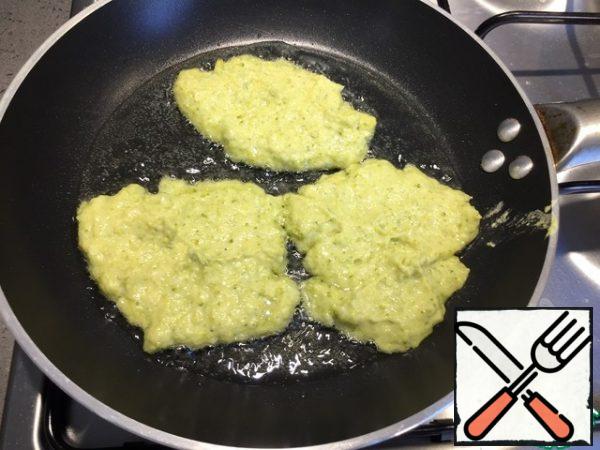 Pour olive oil into the pan and spread the dough in the form of pancakes.