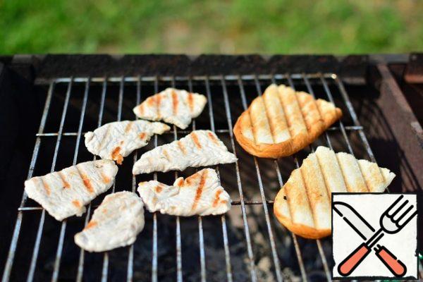 Slices of bread and a Turkey to roast on the grill over the coals. In the process, the meat can be salted as desired.