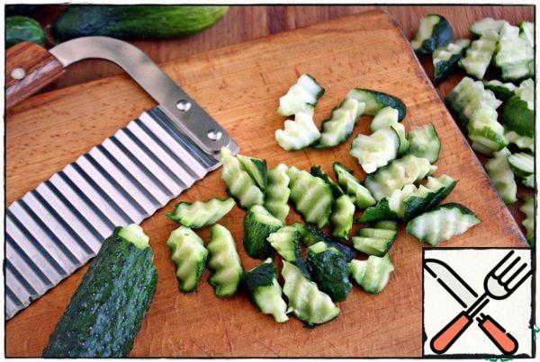 Wash cucumbers, we take such a thing as mine, we cut it.  It will take a minute or two.  If there is no such thing, then cut it as you like, but it still looks more interesting and for some reason cucumbers absorb the marinade better.