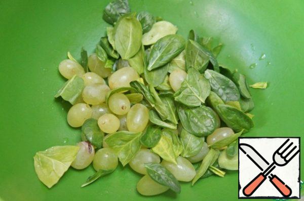 Rinse the spinach and shake off the water, cut off the stalks. Wash the grapes and remove the berries from the twigs. Put everything in a bowl.