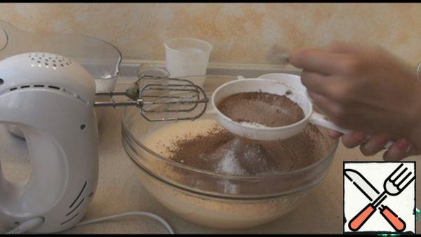 Add vegetable oil, kefir, sift flour, cocoa and baking powder.  Mix well with a spoon or mixer into a homogeneous mass.