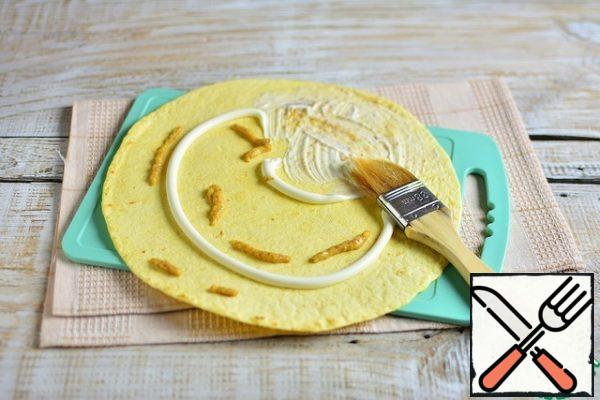 Put half of the mayonnaise and mustard on the tortilla, brush the tortilla with a brush.