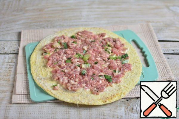 Sprinkle with grated cheese, lay out a thin layer of half the minced meat, retreating from the edges.