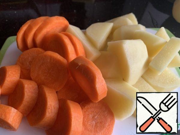 Peel the carrots and potatoes and cut them into slices.