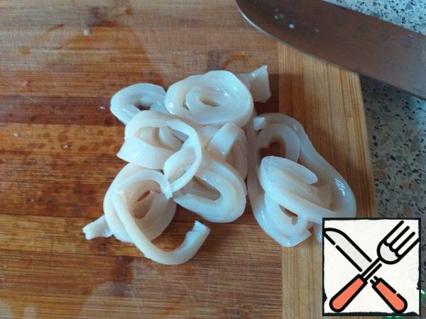 Peeled squid boil for 1-2 minutes. Cool and cut into thin strips.