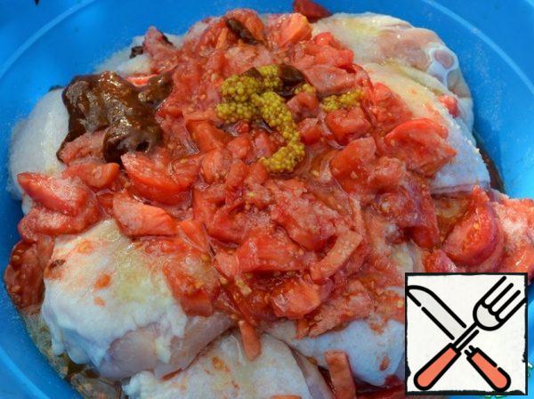 Wash the tomatoes, peel them, and chop them finely.
Add tomatoes, honey, mustard and adzhika to the thighs and season with salt.