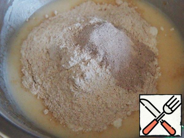 Add both types of flour and baking powder and stir. I have baking powder for gingerbread, so it's dark. You can use, of course, only white flour, but still the presence of a little wholemeal flour in baking greatly improves the taste of the dough, and for Apple baking it is just perfect.