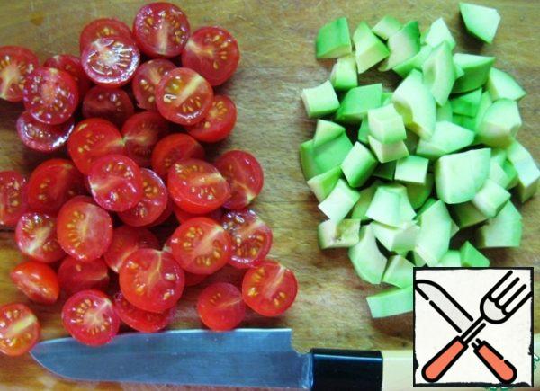 Cut the cherry tomatoes in half, peel the avocado and cut into small pieces.
