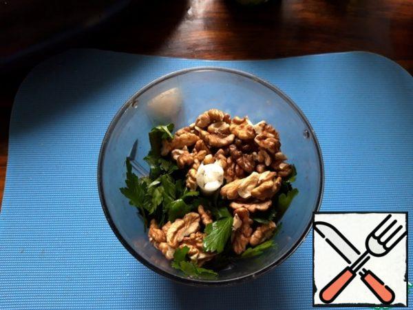 Coarsely chop the greens, put them together with the walnuts in a blender bowl and chop.
